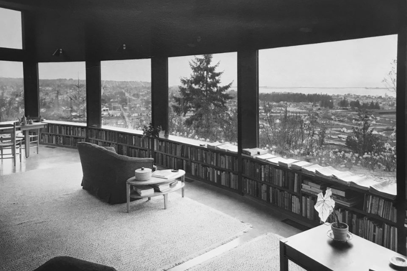Black and White photo of the view over town from gallery windows. Furnishings and bookshelves included.
