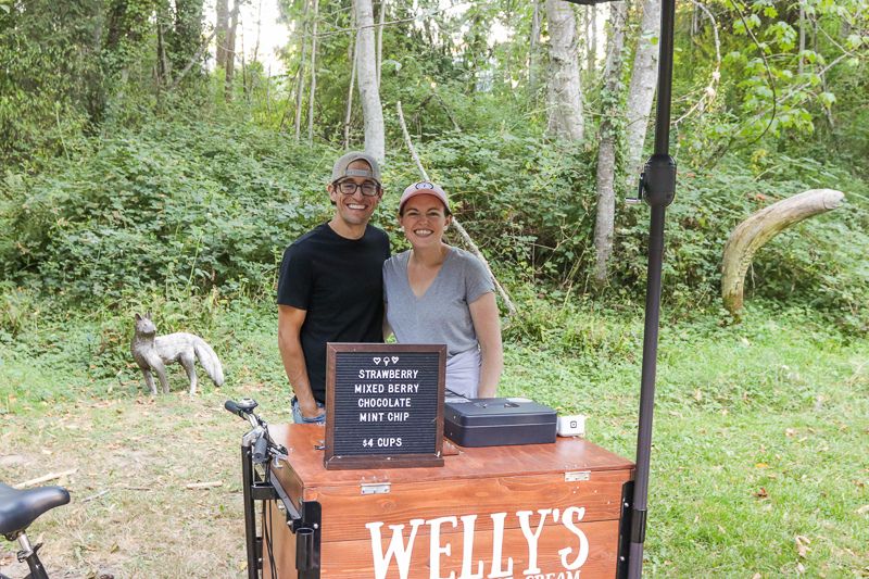 Image from String and Shadow performance "Ship of Fools" in meadow, 2023. Welly's Ice Cream vending on bike