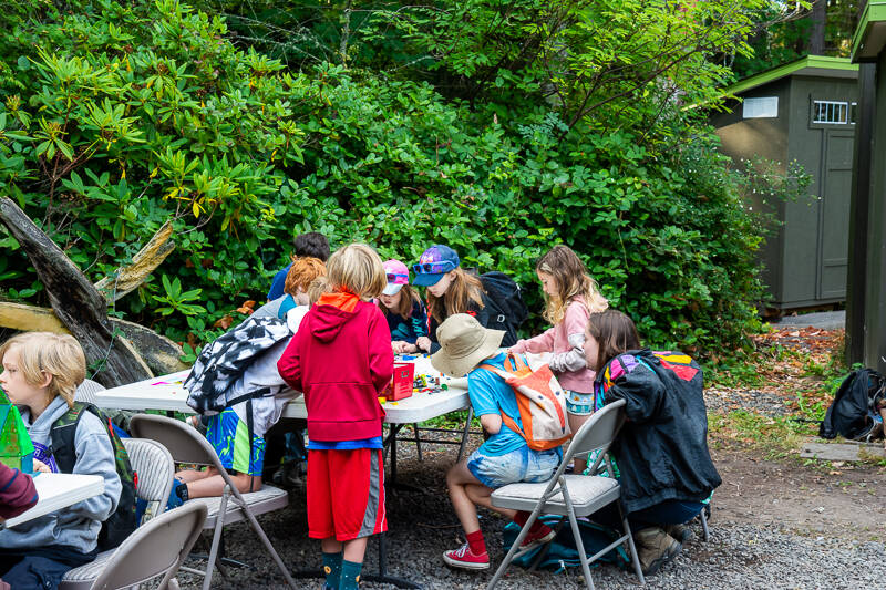Students gathered around a table in the courtyard at summer camp 2023
